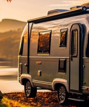 a silver camper trailer parked on a rocky shore