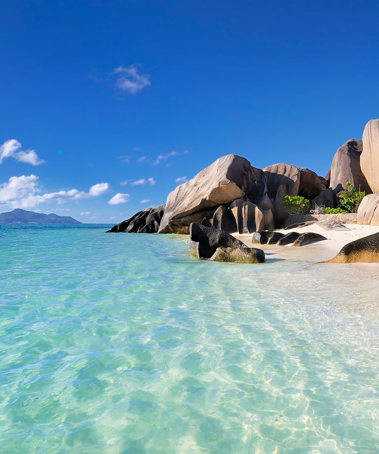 Idyllic Seychelles beach with granite boulders, white sand, and turquoise water.