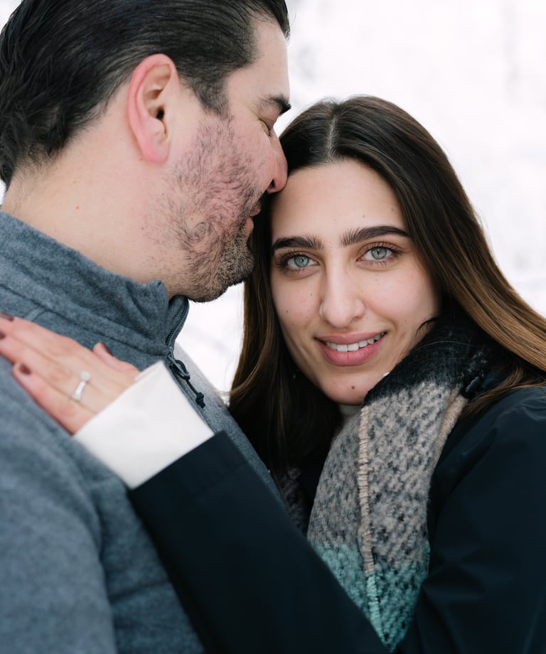 a man and woman standing in the snow