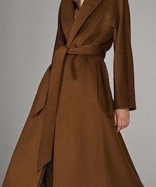 a woman in a long coat and boots
