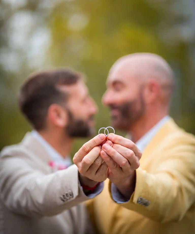 "Pareja gay casada mostrando sus anillos de boda en Madrid, celebrando su amor y unión."