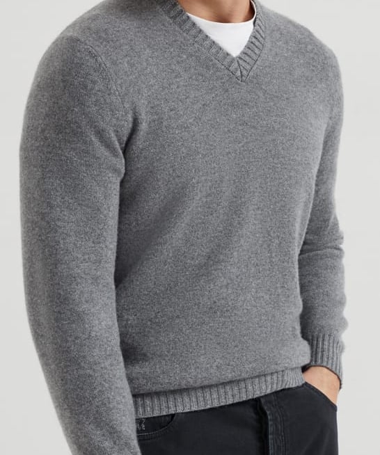 a man in a grey sweater and black pants