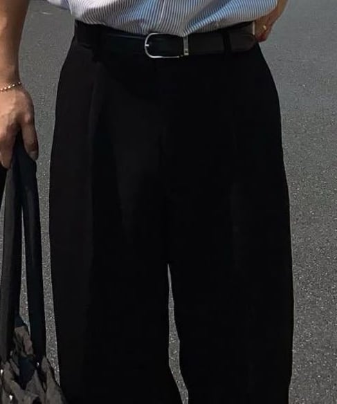 a man in a shirt and pants standing in the street