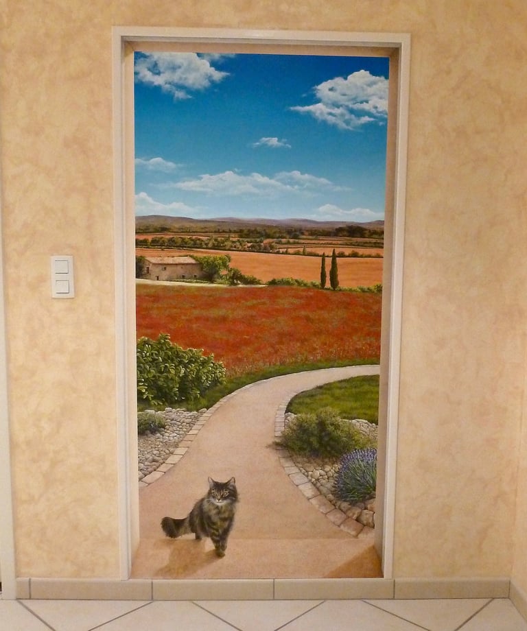 Une porte ouverte sur un paysage méditerranéen, une allée, un chat...Un décor en trompe-l'oeil pour une porte murée.