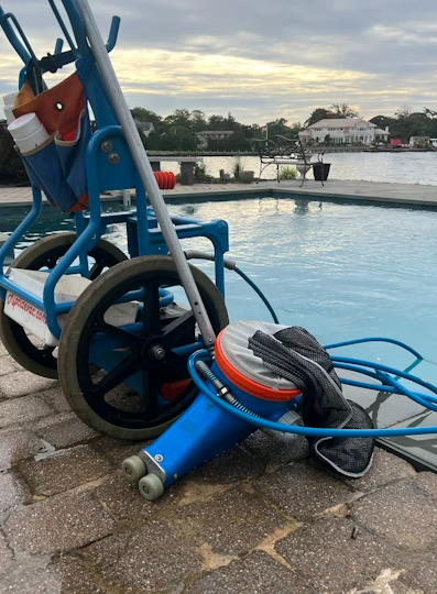 Equipamento profissional de vácuo e manutenção de piscina em um carrinho azul perto de uma piscina n