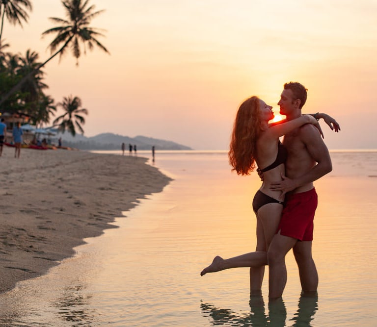 a sugar baby and sugar mommy kissing on the beach in Sydney.