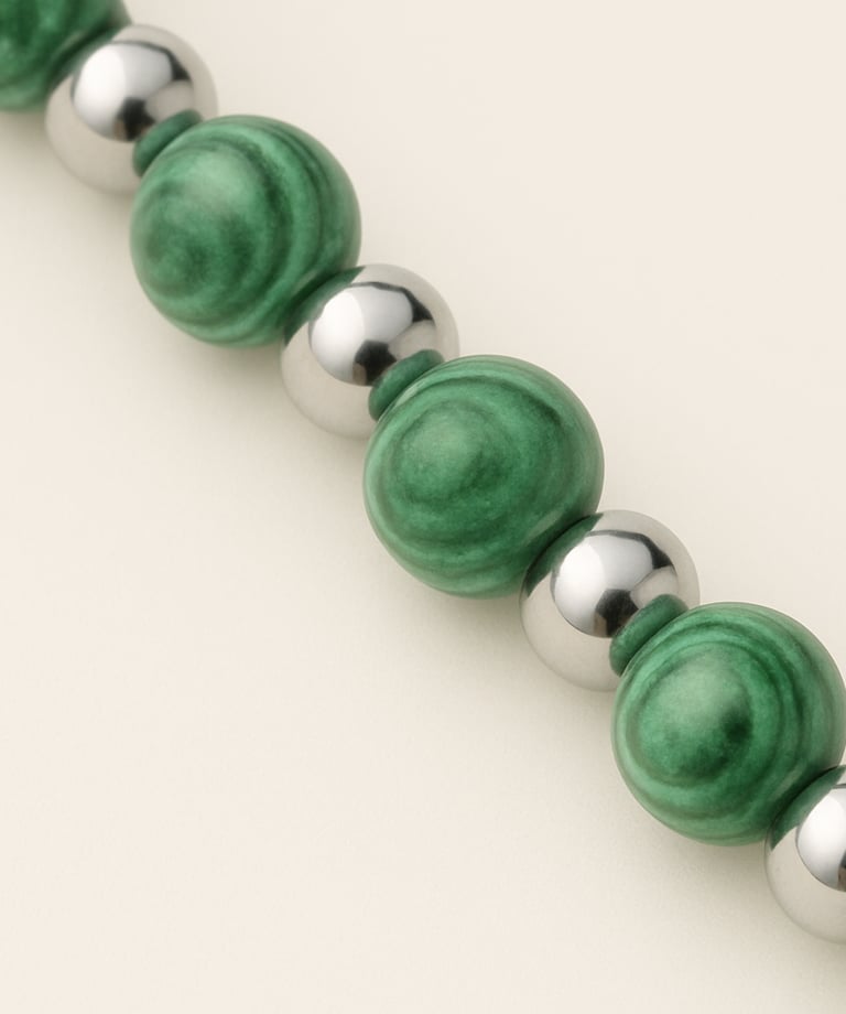 a green beaded bracelet bracelet with a silver ball