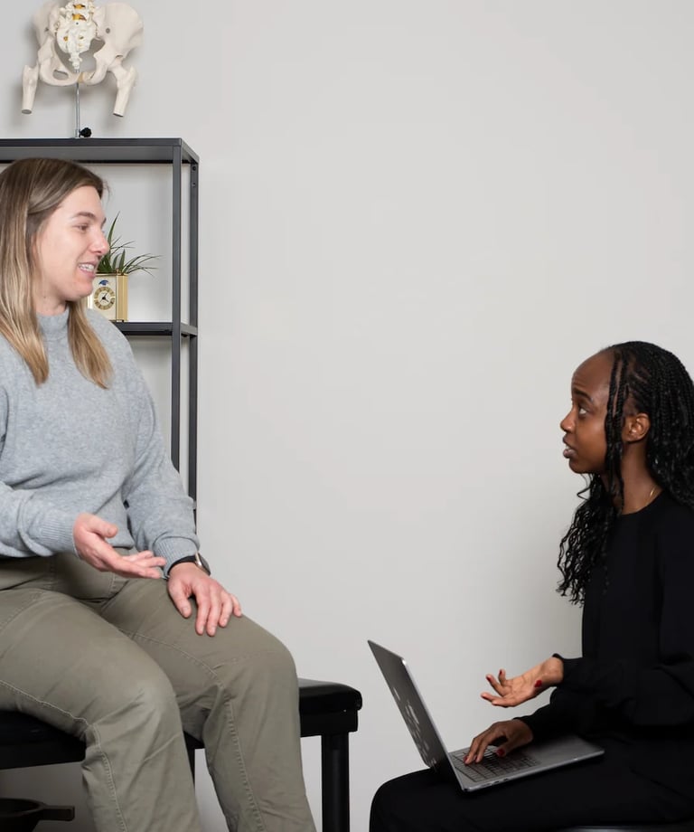 Practitioner explaining osteopathy to a patient on treatment table in JD Osteopathy Mississauga