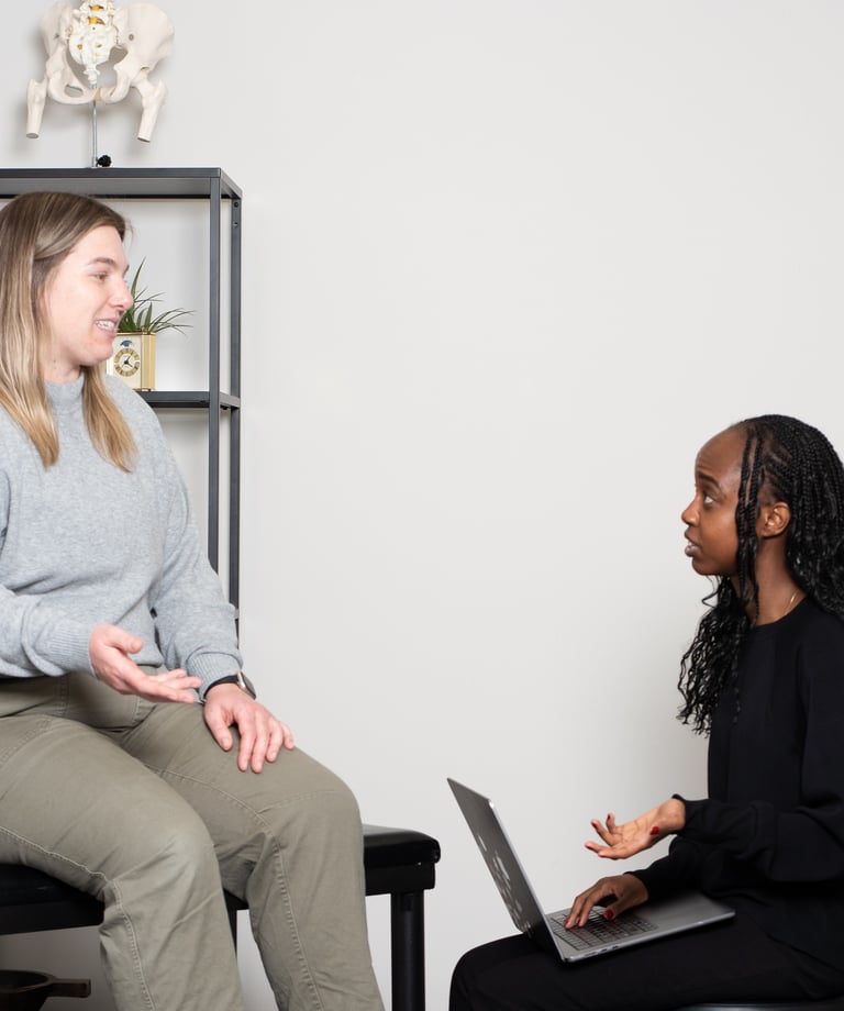 Practitioner explaining osteopathy to a patient on treatment table in JD Osteopathy Mississauga