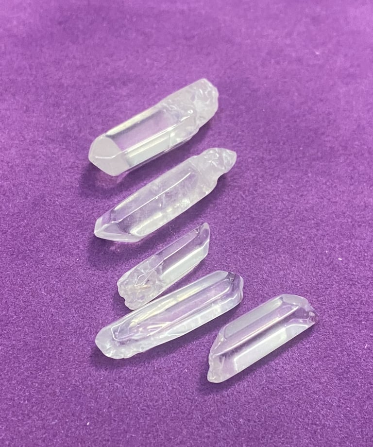 different sized white crystals on a purple background
