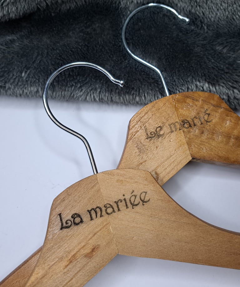 a wooden hanger with a pair of clothes hangers