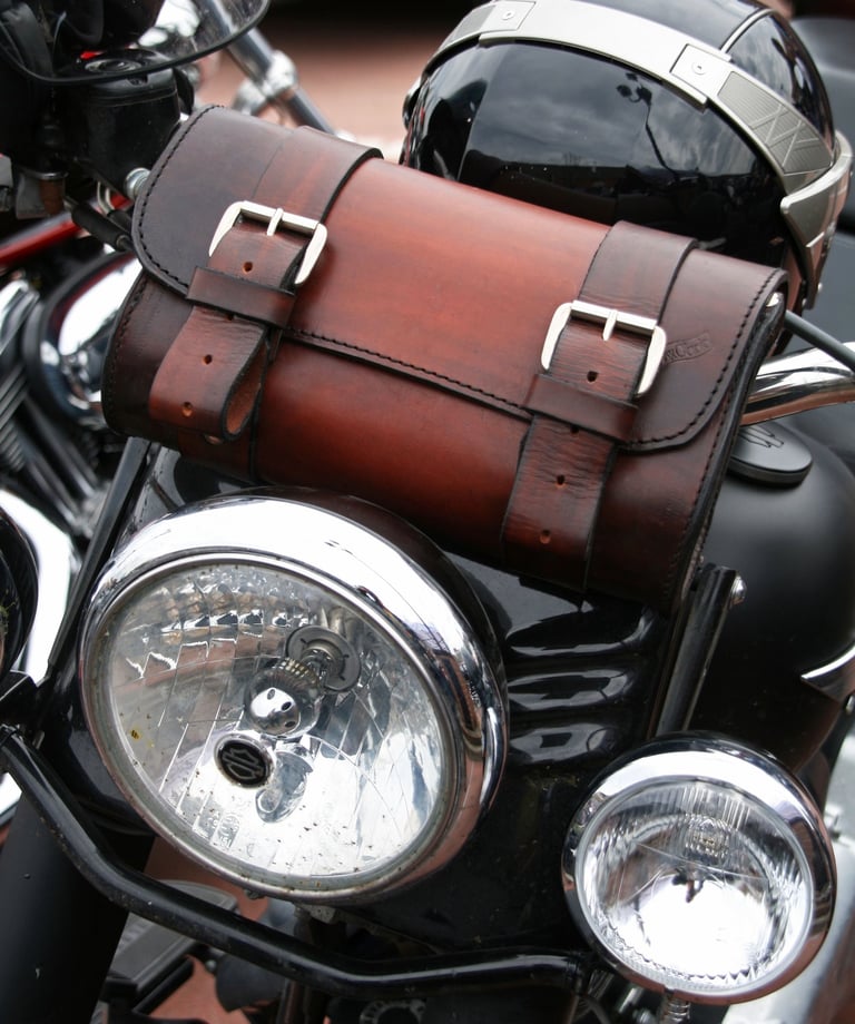 Borsa per attrezzi in cuoio marrone di MaxCuoio appoggiata su una moto