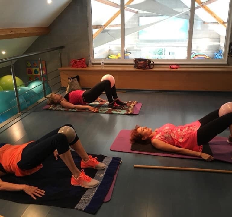 Un groupe de personnes faisant des exercices de yoga sur un tapis.