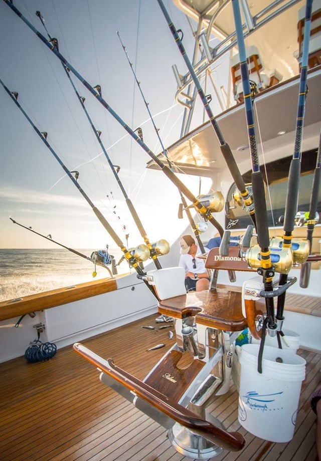 a man fishing on a boat with fishing rods