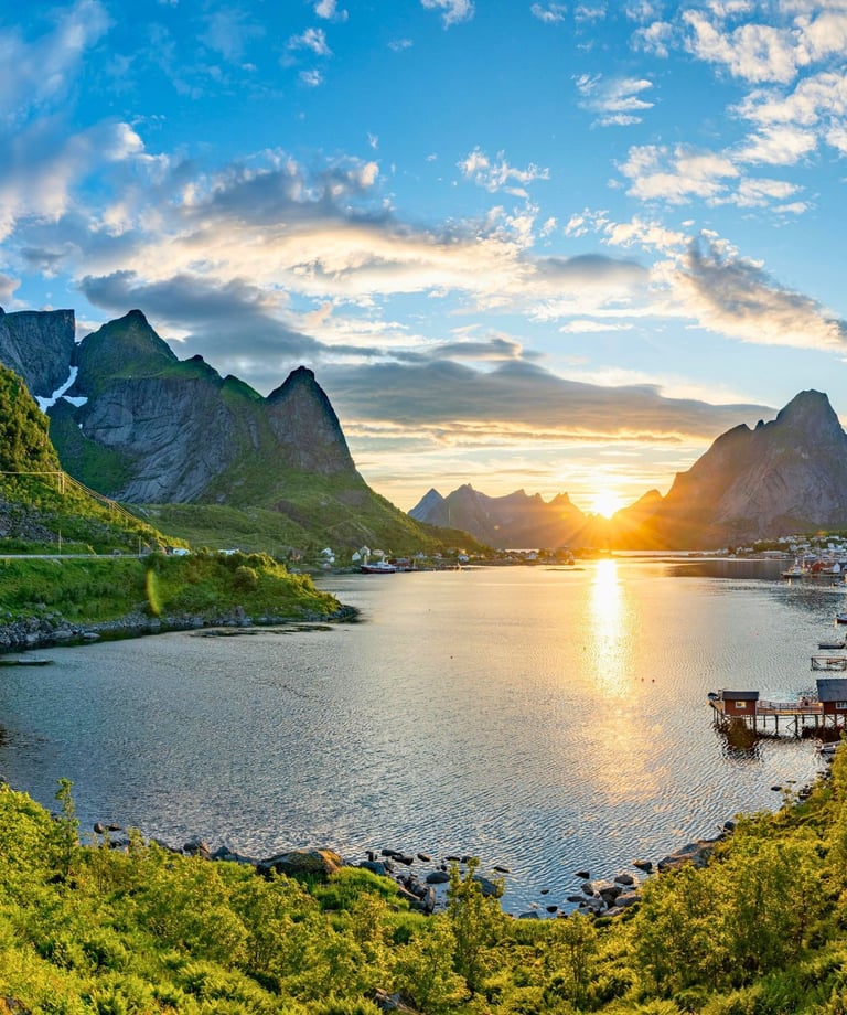 Scenic sunset over Reine village in Lofoten Islands, Norway, with mountains and coastal fjords.