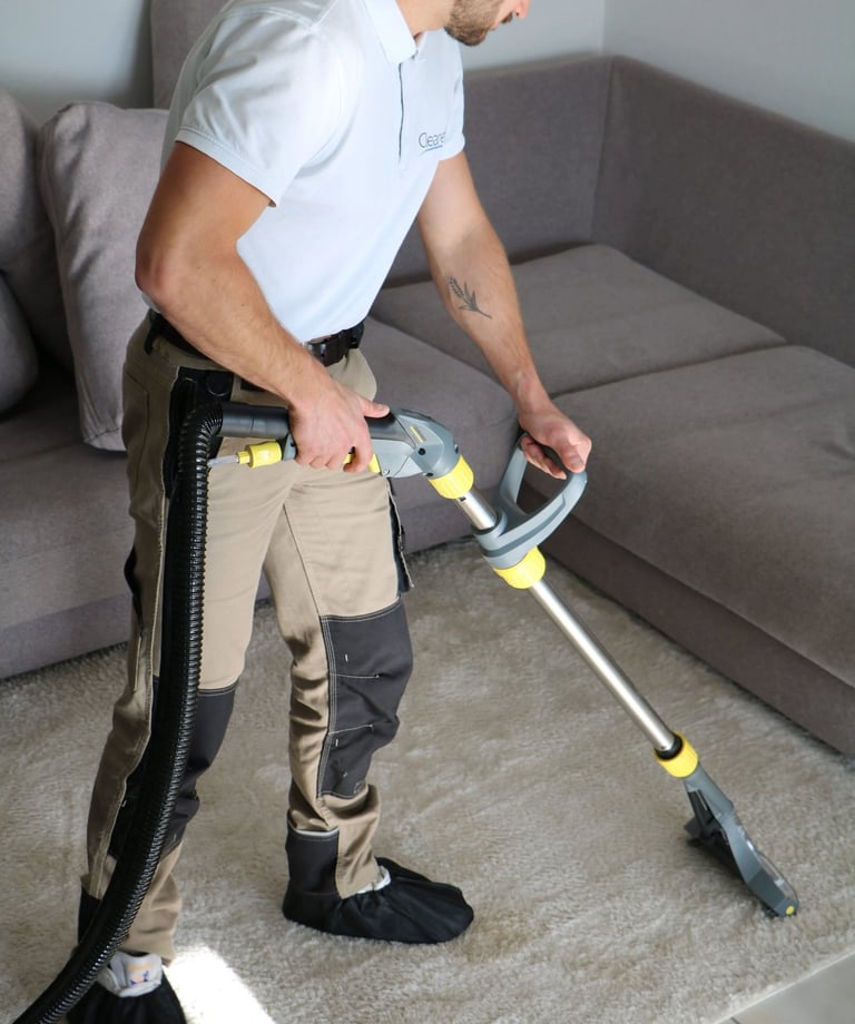 a man in a white shirt is using a vacuum cleaner
