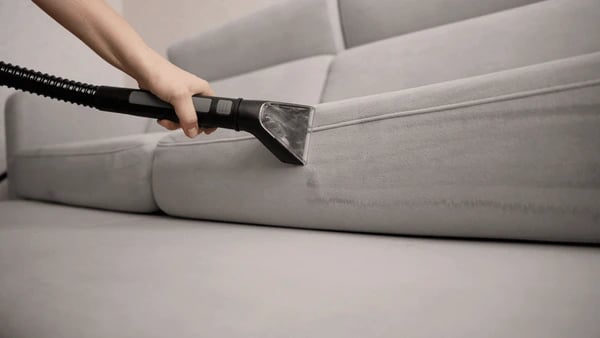 Nettoyage canapé gris avec aspirateur professionnel - service mobilier textile Paris Presti Clean+