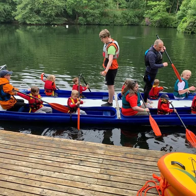 Beaver Scouts paddling a bell boat at the marina