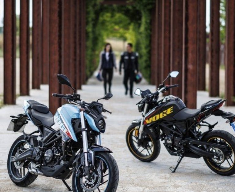 a motorcycle parked on a rocky river bank