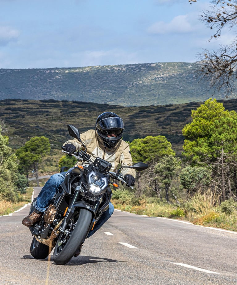 vyras, važiuojantis motociklu keliu