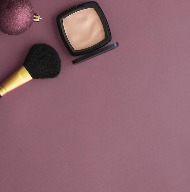 a makeup brush and a brush on a purple background