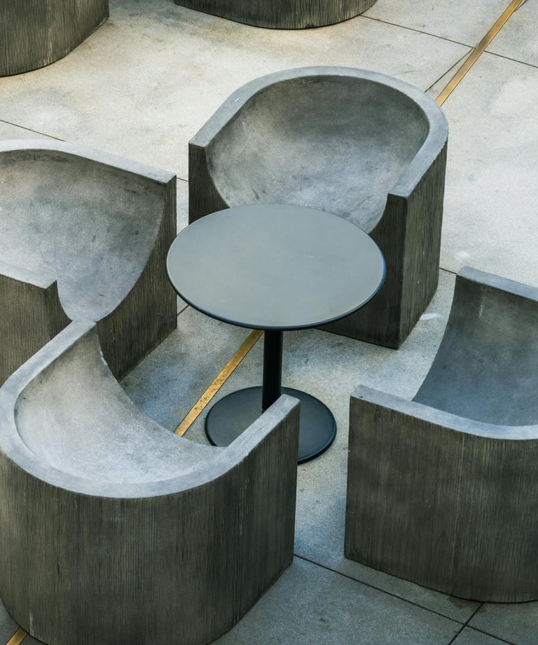 Mobilier d'extérieur moderne composé de quatre fauteuils en béton arrondis et une petite tabl