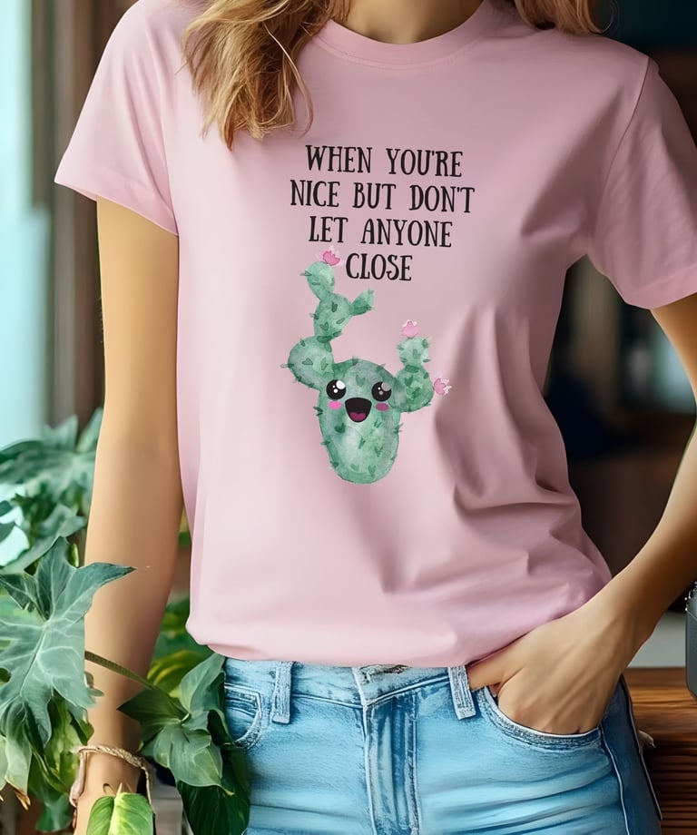Woman wearing a pink graphic plant t-shirt with a cute smiling cactus design from Miss Chatty Plants.