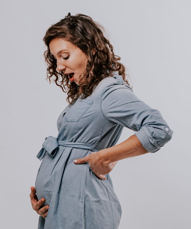 une femme enceinte qui regarde son ventre avec surprise