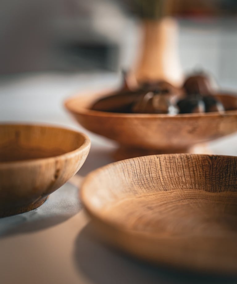 Composition artistique mettant en avant plusieurs bols et plats en bois faits main, posés sur une ta