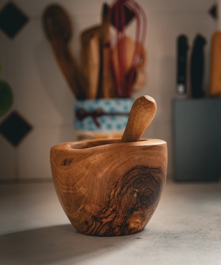 Mortier en bois massif artisanal accompagné de son pilon, posé sur un plan de travail dans une cuisi