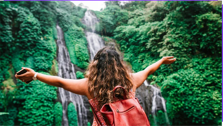 Sophro-balade :Femme ressentant l'énergie d'une cascade en forêt, moment de sérénité et reconnexion