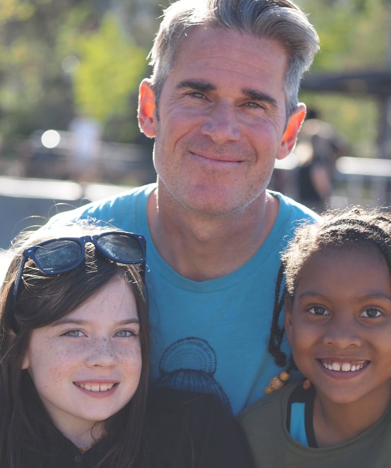a man with two young girls smiling