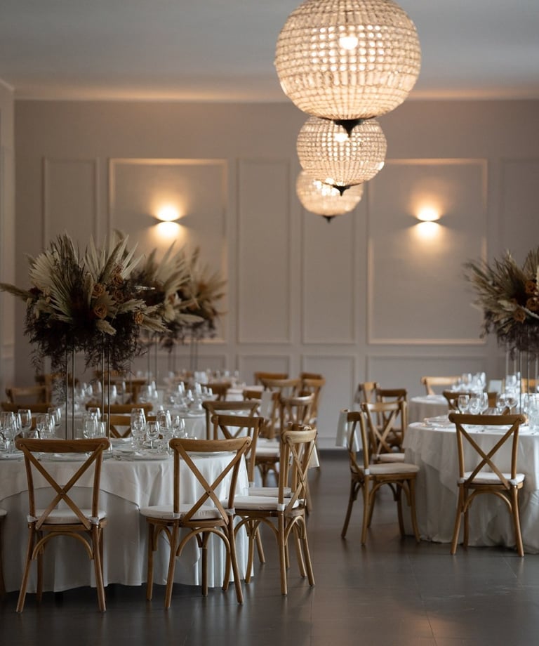 wedding table with white tablecloth and chairs and a chandelier
