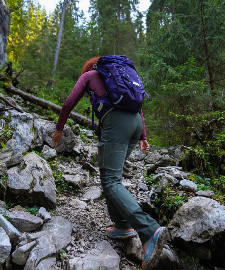 Hiker equipped with helmet and harness on exposed section of Sentiero Bonacossa trail.