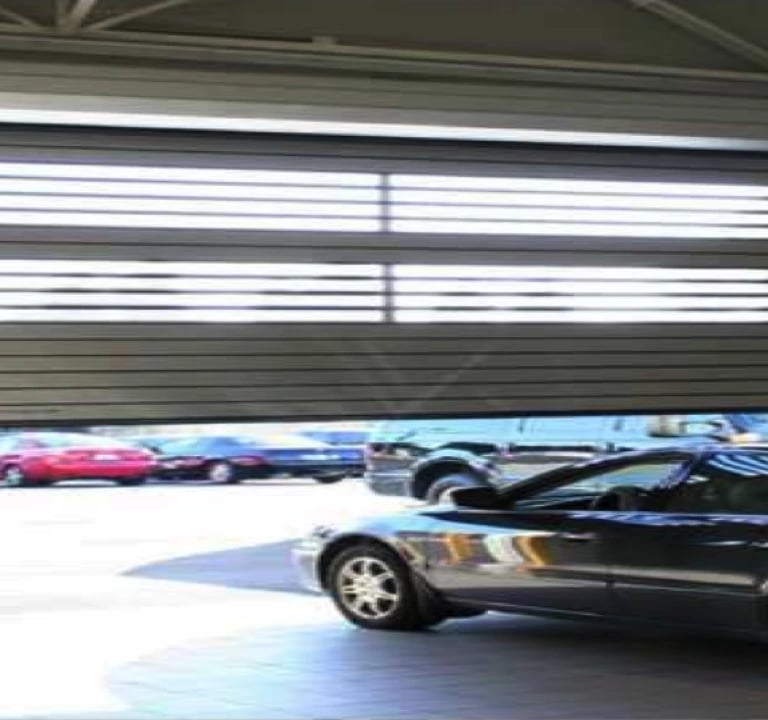 a car parked in a garage with a car parked in front of it