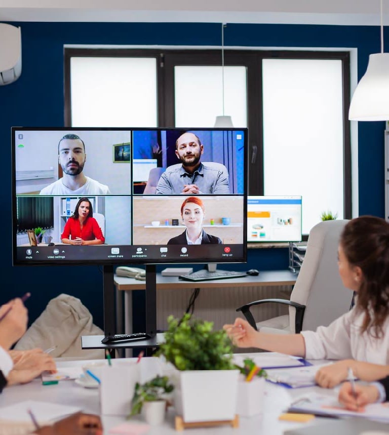 Hybrid meeting setup with participants on video call and in-person around a conference table – Sonus AV rental Dubai