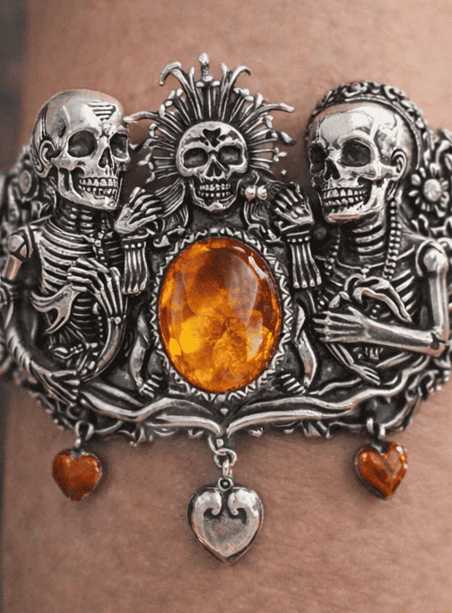 Brazalete en plata Mictlan ornamentada con calaveras y una gran piedra de ámbar en el centro.
