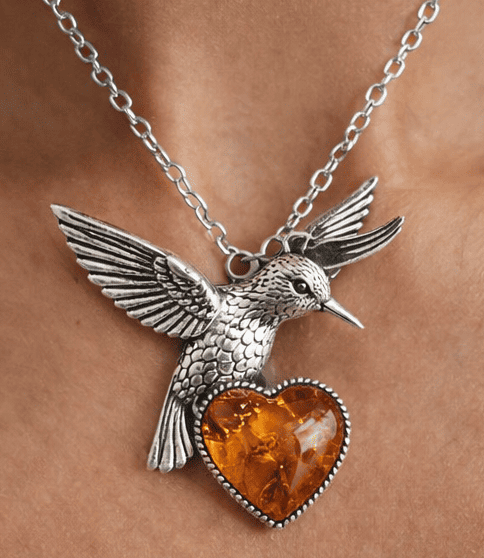 Collar-en-forma-de-colibrí-en-plata-con-un-decorado-en-forma-de-corazón-de-ámbar-brillante