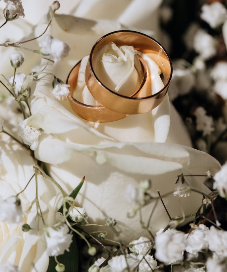 a couple of wedding rings on a bouquet of flowers