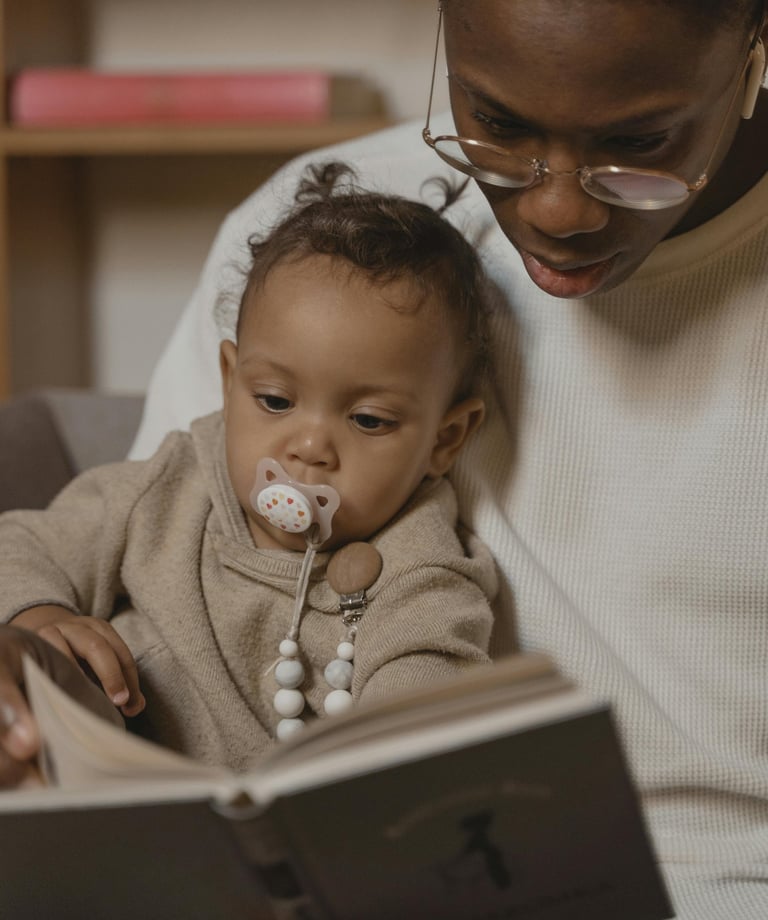 a woman is sitting on a couch while reading a book