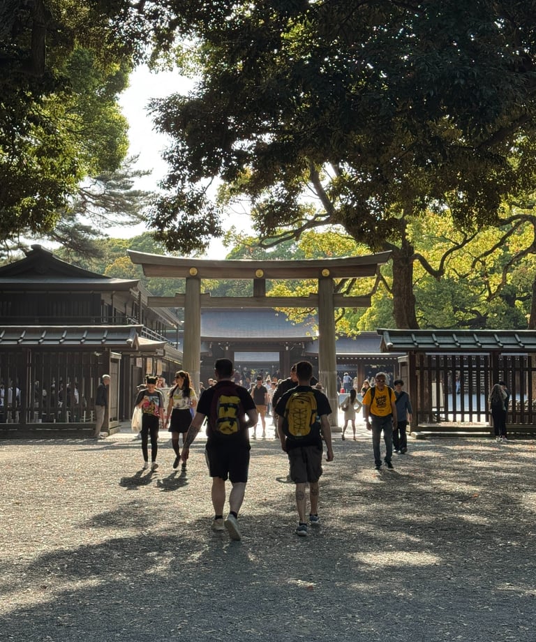 Tourists walking toward the wooden Torii gate entrance of Meiji Jingu Shrine in Tokyo, Japan.