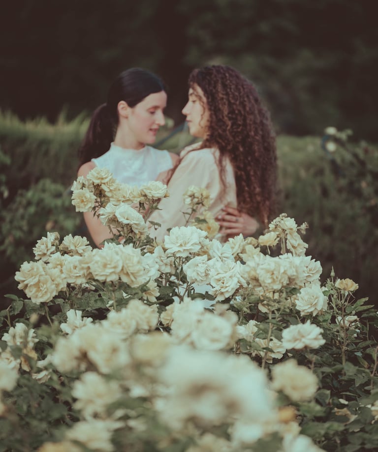 "Pareja lesbiana con flores de rosa blanca, celebrando su compromiso en una boda gay."