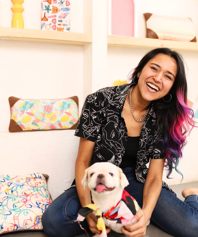 a woman sitting on the floor with a dog in her lap