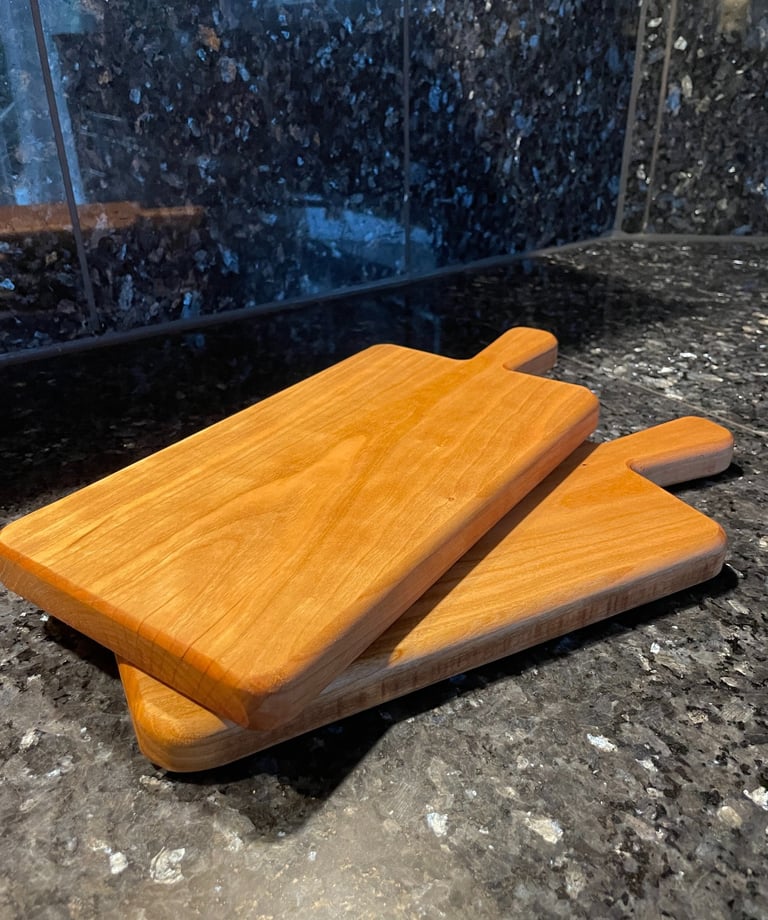 Zwei Servierbretter aus Kirschholz auf einer Küchenplatte
