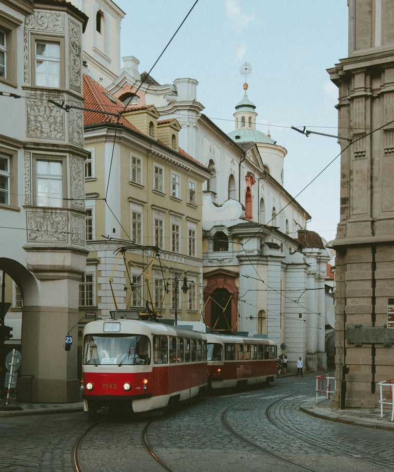 Ein roter Straßenbahnwagen fährt die Gleise herunter