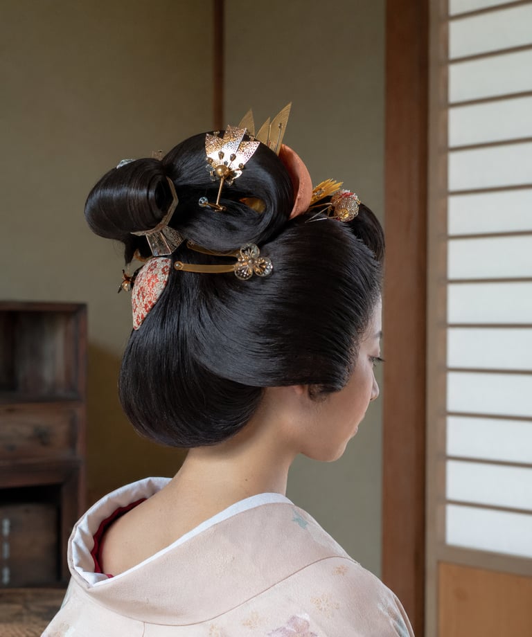 Traditional Japanese geisha hairstyle with ornate gold kanzashi hair pins and silk kimono.