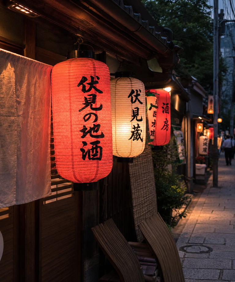 Traditional red and white Japanese paper lanterns hanging outside a restaurant on a Kyoto street at night.