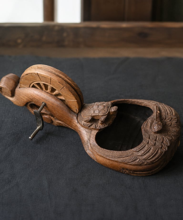 Antique Japanese hand-carved wooden sumitsubo ink pot featuring turtle and bird motifs on a dark surface.