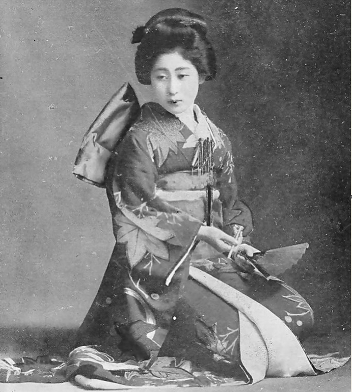 Vintage portrait of a Japanese woman in a traditional floral kimono and obi, holding a folding fan.