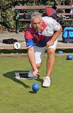 A face on view of a porthcawl bolws club lawn bowler playing bowls